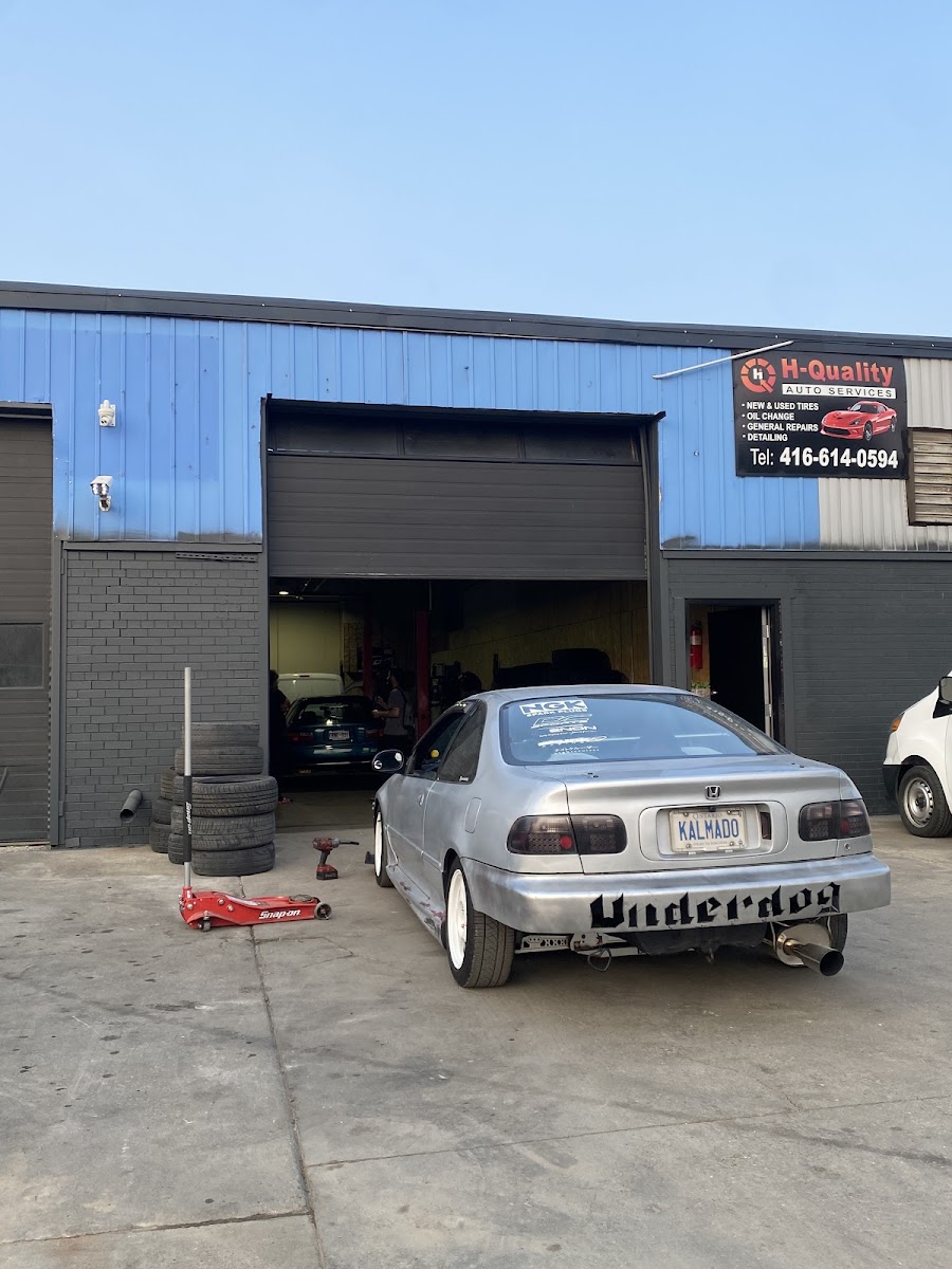 A silver Honda Civic with an &lsquo;Underdog&rsquo; rear bumper parked at the bay door at dusk.